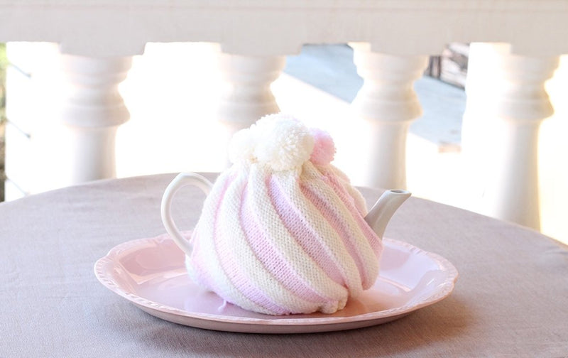 ice cream swirl tea cosy with pink and white stripes on a table