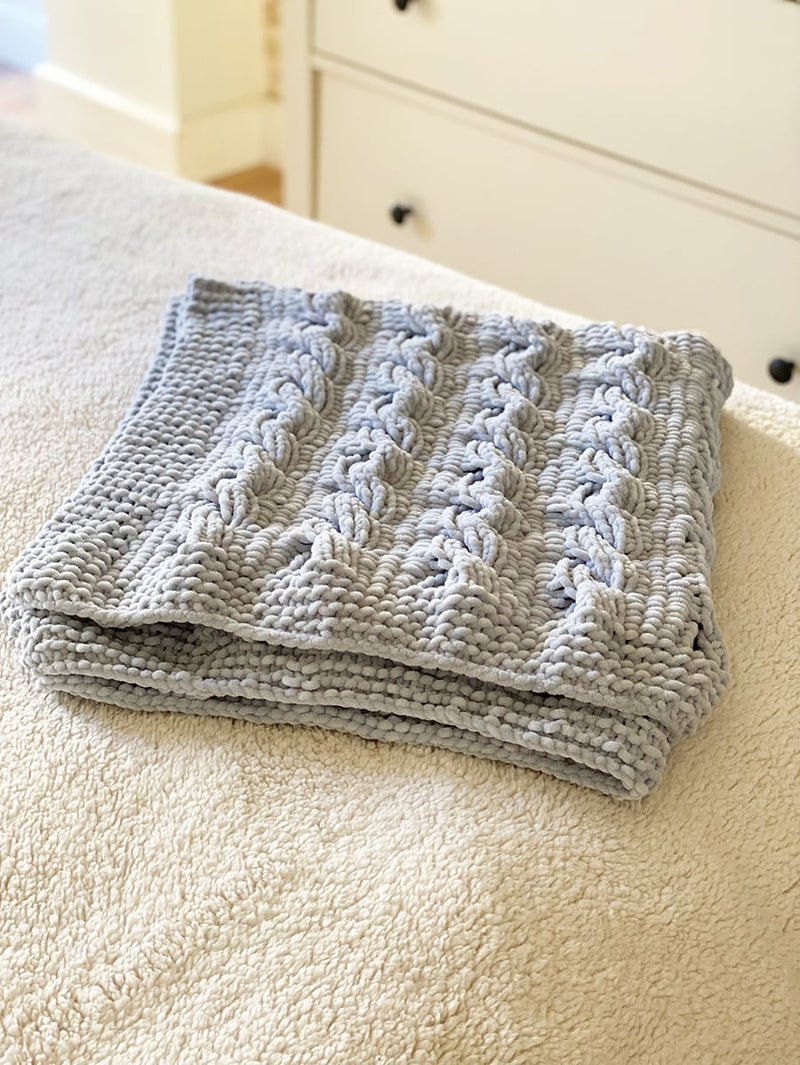 baby blanket folded with cables