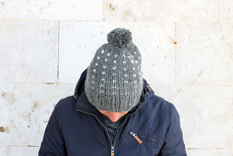 Man with his head down wearing a grey knit hat