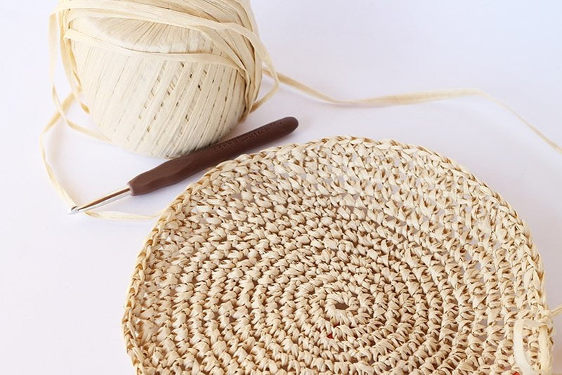 a circle made from raffia with a crochet hook