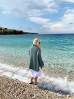 woman at the beach wearing a baggy sweater