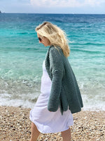 woman on the beach wearing an oversized knit sweater