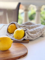 lemons on a cutting board with a crochet produce bag