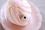 spout view of the pink and white knitted tea cosy